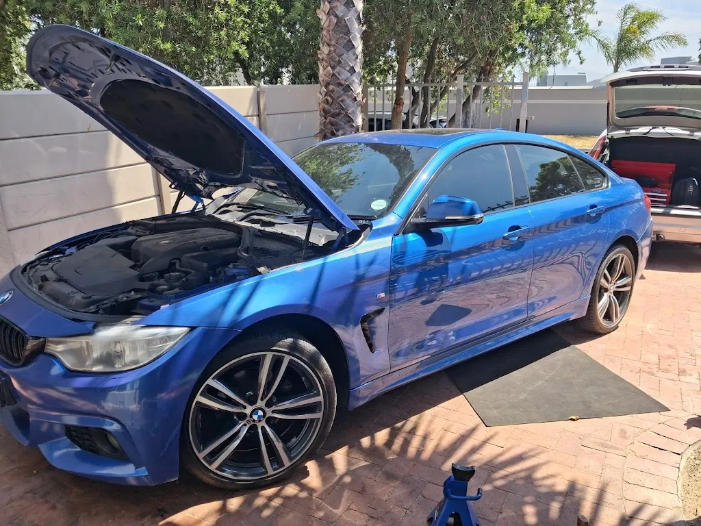 Blue BMW 4 Series M Sport driveway repair on jack by Mobile Vehicle Diagnostics mobile mechanic in Cape Town